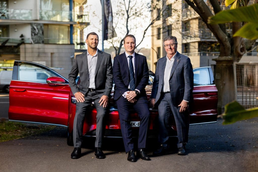 team portrait by red car for press release